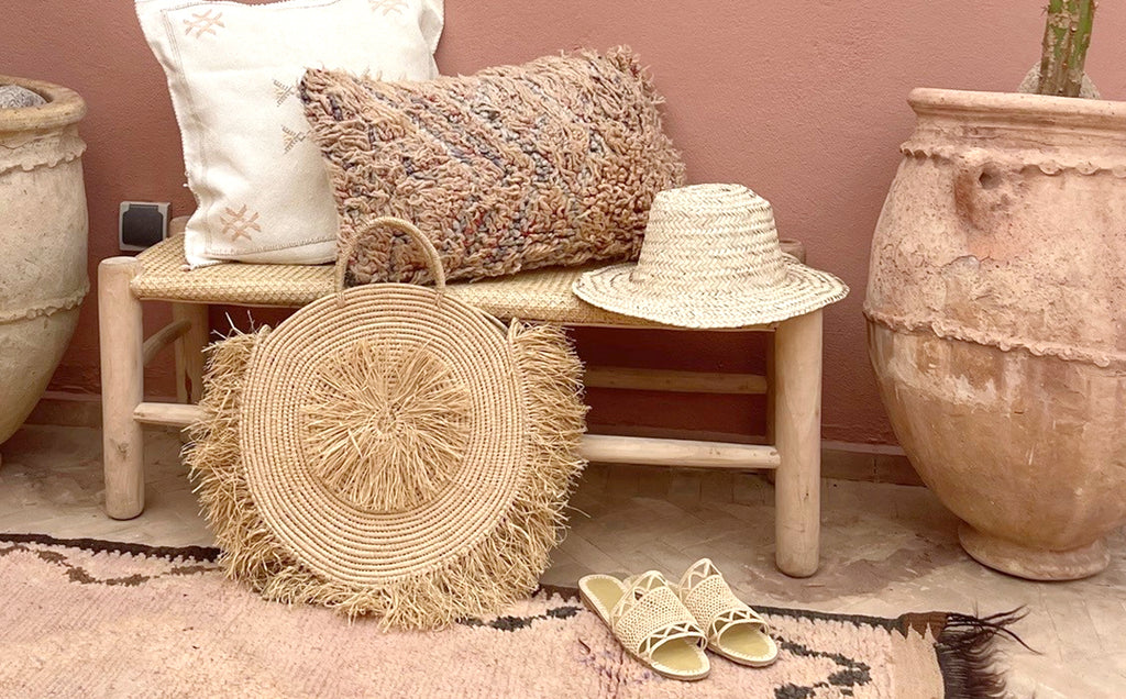 A stunning Moroccan rug with a mix of straw hat, bag, and shoes, all handmade available from Moroccan Tribe in Australia.