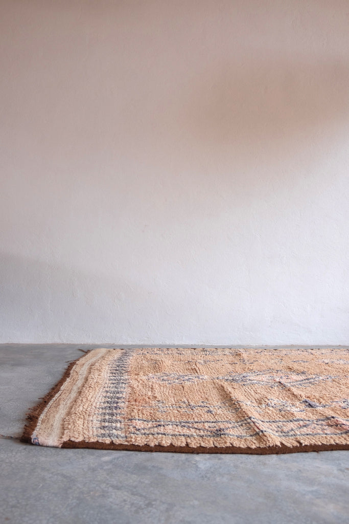 Vintage Moroccan rug with traditional tribal motifs and neutral colors.