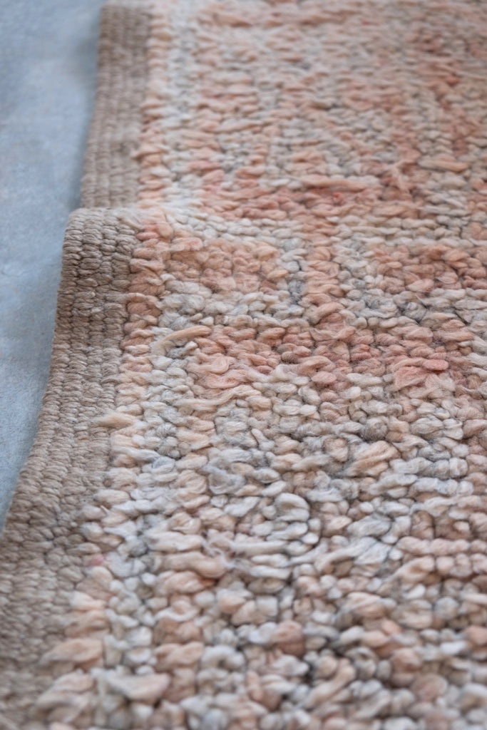 The vintage Moroccan rug showcases intricate tribal patterns, available at Moroccan Tribe.