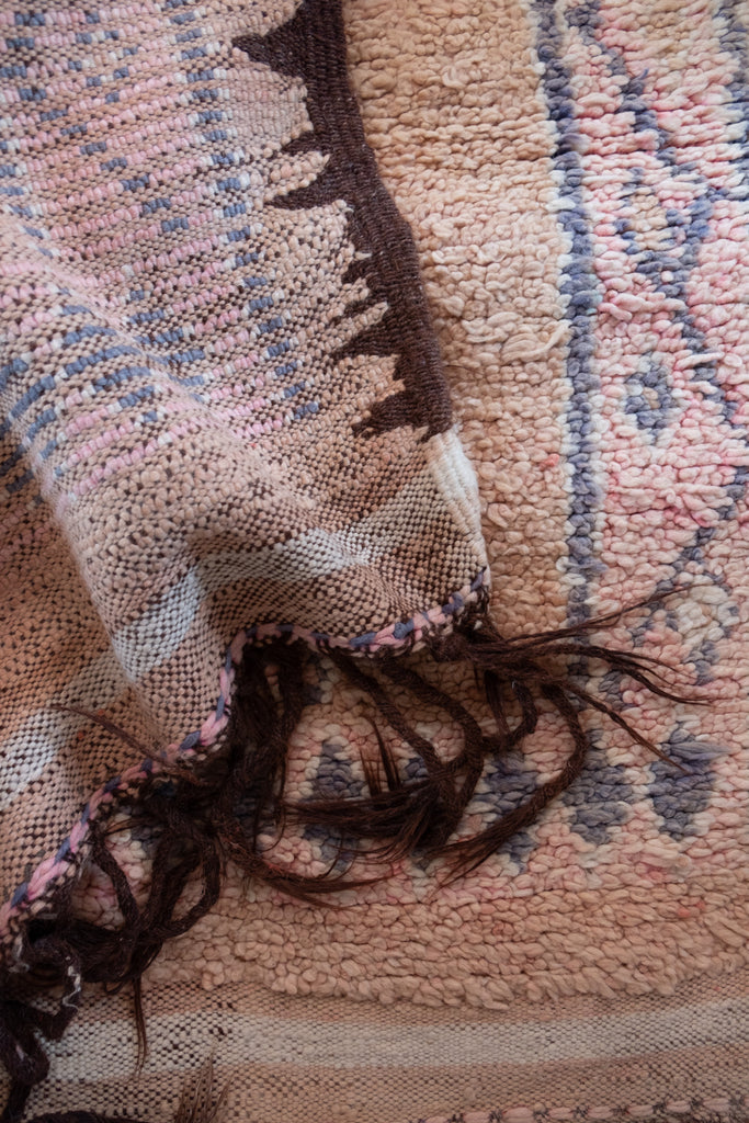 Vintage Moroccan rug featuring intricate tribal designs.
