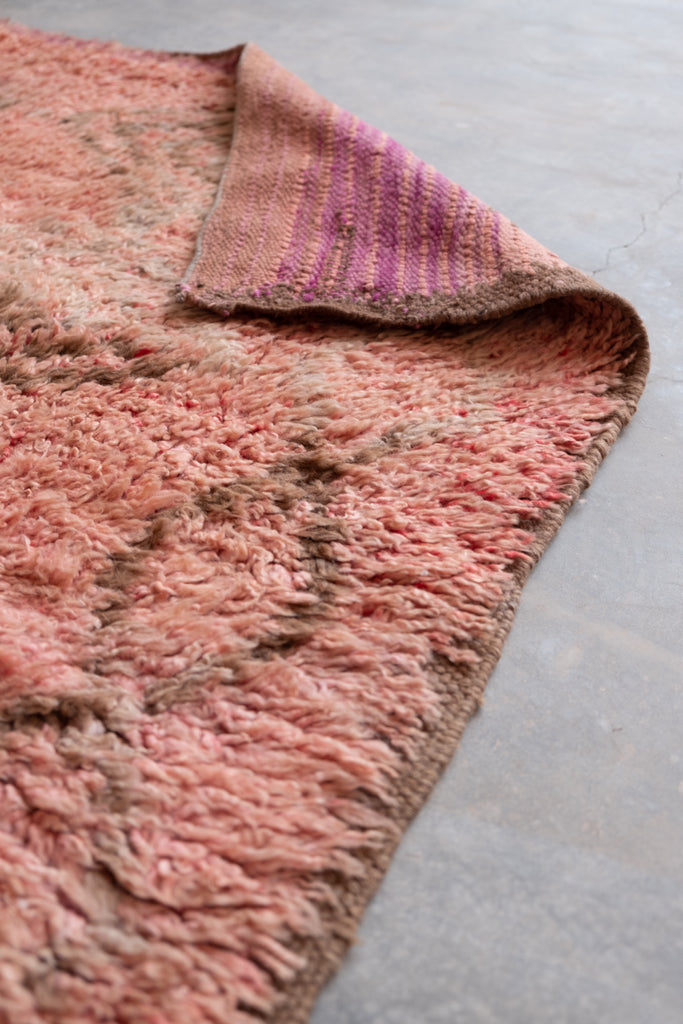 Vintage Moroccan rug featuring neutral colors and tribal patterns.