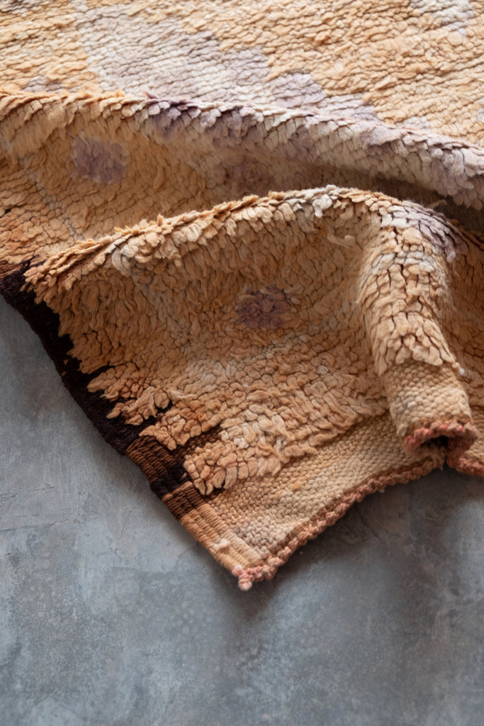 Vintage Moroccan rug displaying traditional tribal motifs and neutral colors.