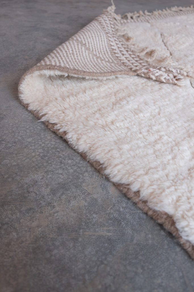 Contemporary Moroccan rug displaying intricate patterns and neutral colors.