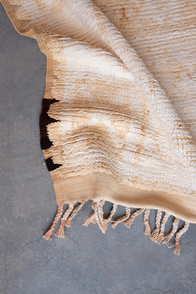Vintage Moroccan rug displaying neutral colors and traditional motifs.