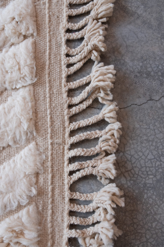 Vintage Moroccan rug featuring tribal-inspired patterns and neutral colors, suitable for various spaces.