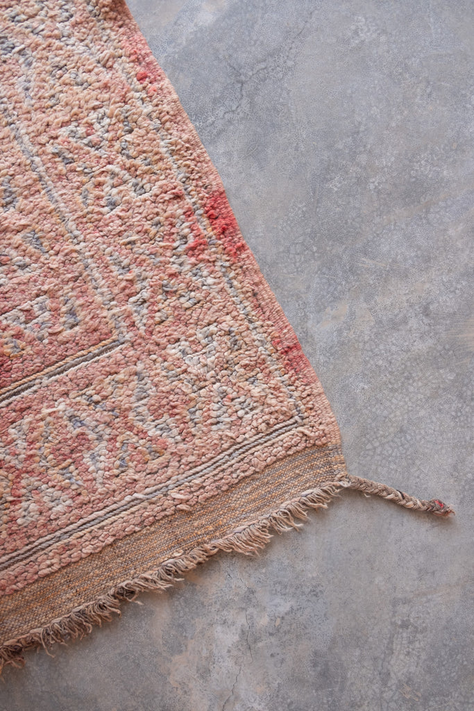 Vintage Moroccan rug featuring neutral colors and traditional motifs.